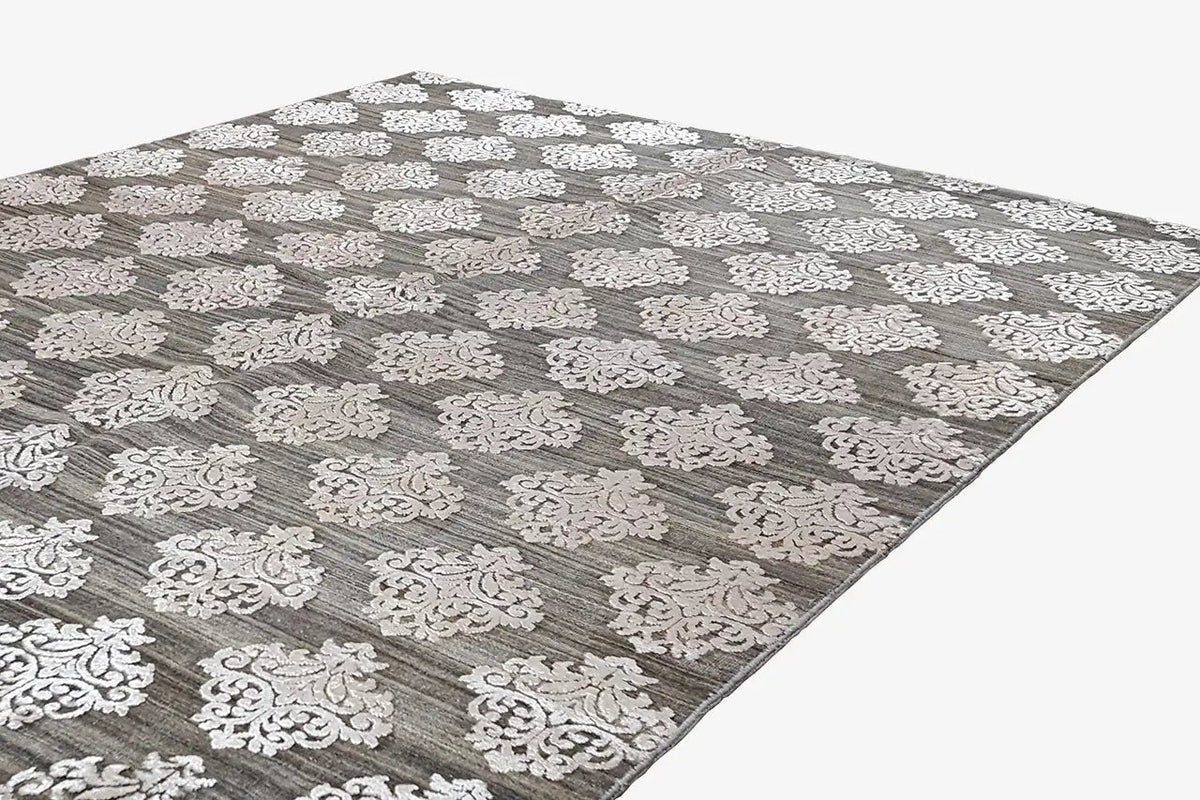 Designer rug with gray pile and white ornamental pattern, photographed diagonally