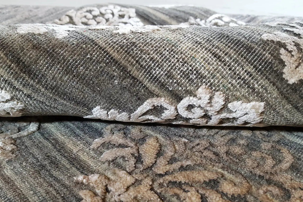Carpet detail: gray pile with white ornaments and visible edge binding