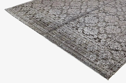 Rug with a dense vintage relief pattern in gray and dark gray, narrow border