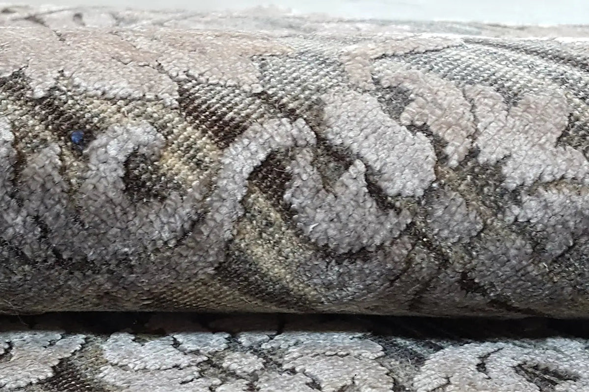 Carpet detail: woven relief pattern in gray, with dark contrasting ornaments