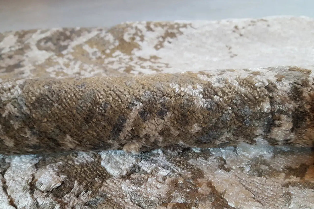 Carpet surface with visible pile marks and a worn vintage pattern in brown and blue