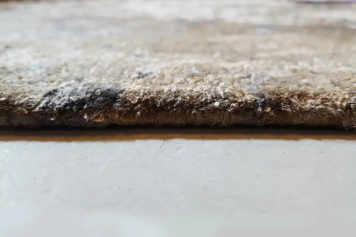 Rug edge with dense pile and faded vintage design, brown-beige with blue