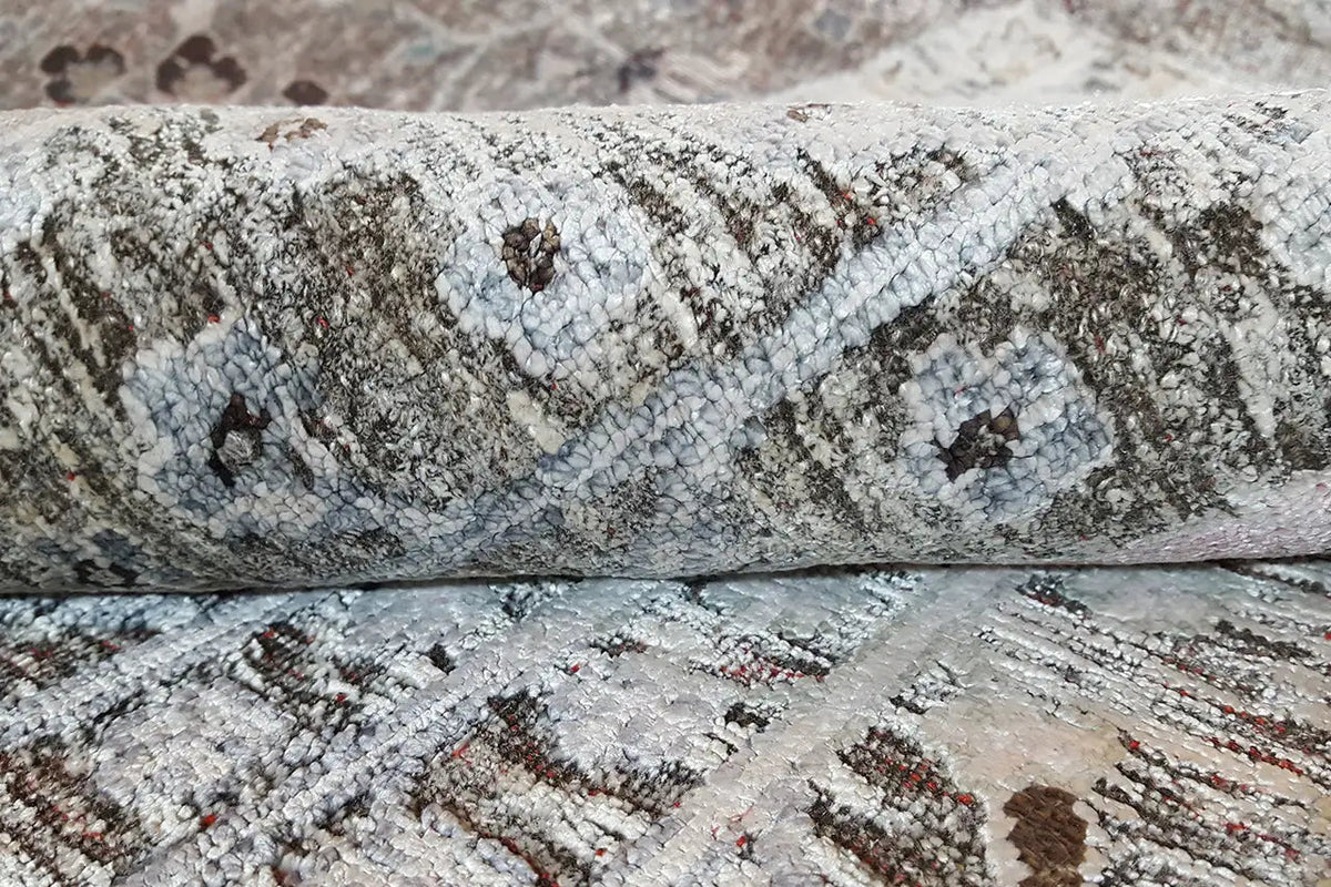 Rug detail: textured pile fibers in gray, with multicolored fiber strands