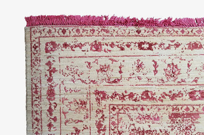 Rug detail: floral ornaments on a light background, pink pile border