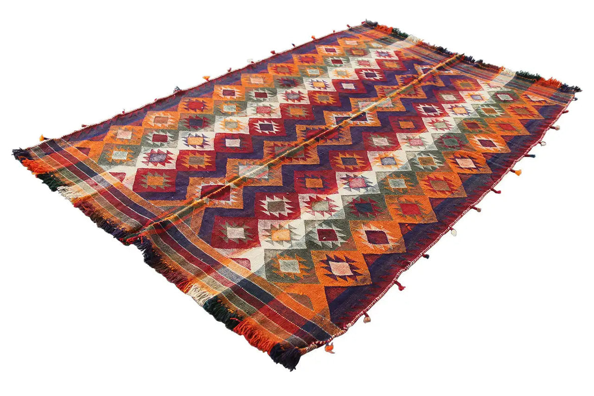 Triangular-looking rug with zigzag and diamond patterns in orange, blue, and red