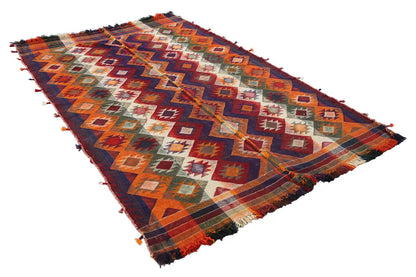 Kilim rug with geometric chevron patterns, colorful tones, frayed edges