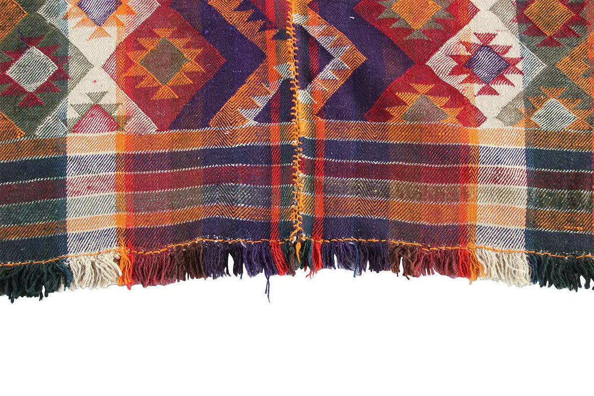 Close-up: Carpet edge with fringes and multicolored plaid patterns