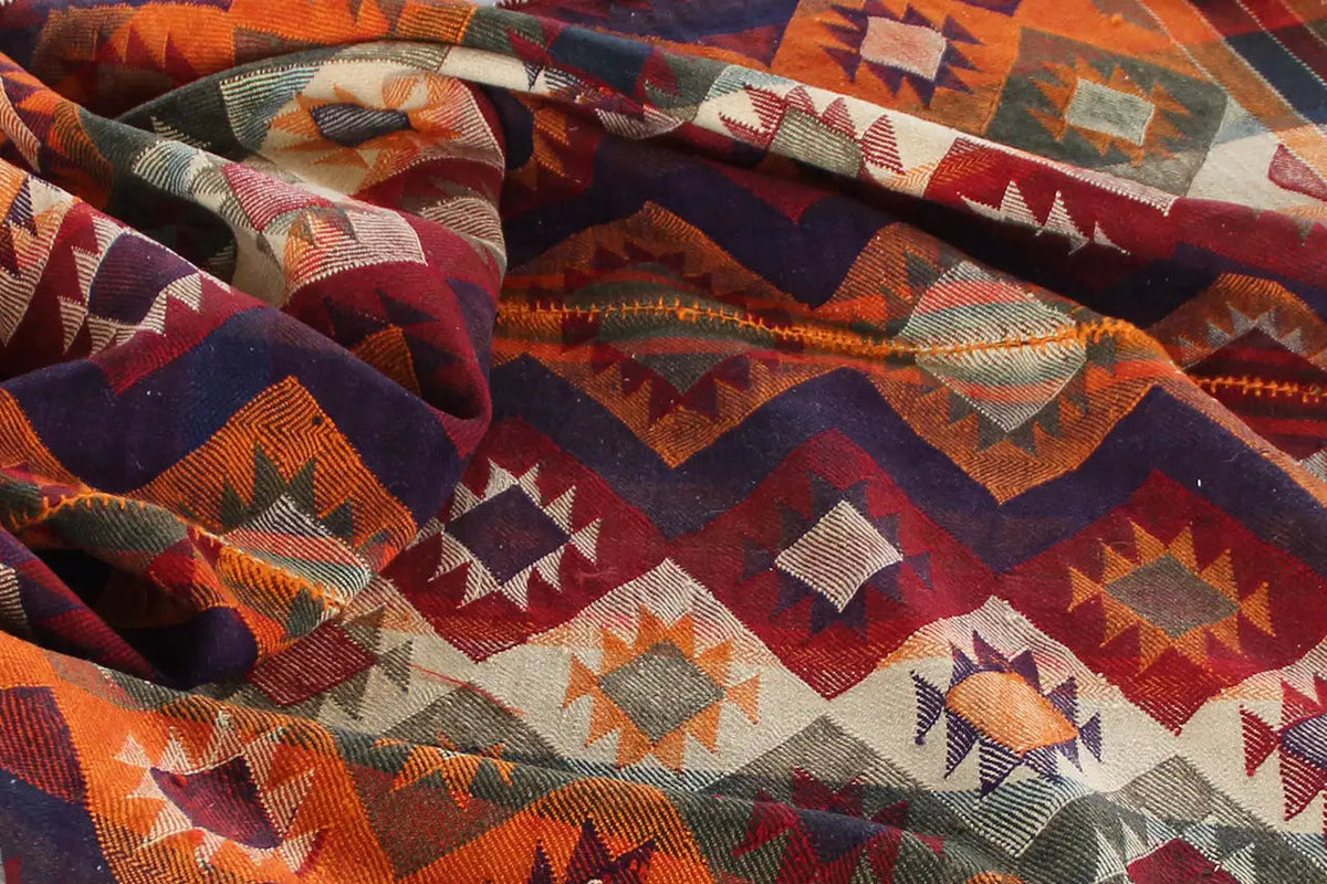 Close-up of the fabric: dense geometric patterns in orange, blue, red, and gray
