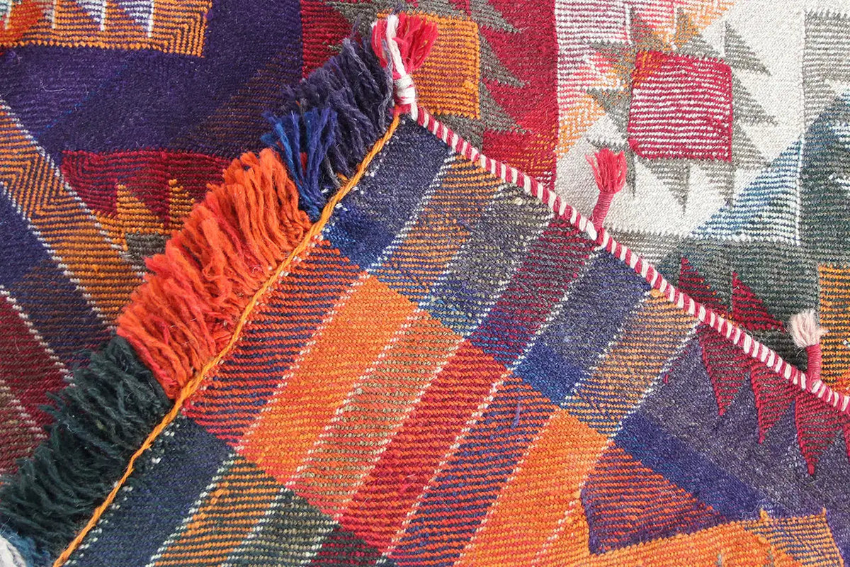 Close-up with fringe and orange-blue zigzag stripes as well as diamonds