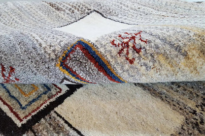 Gabbeh rug with multicolored decorative patterns on a beige background, close-up