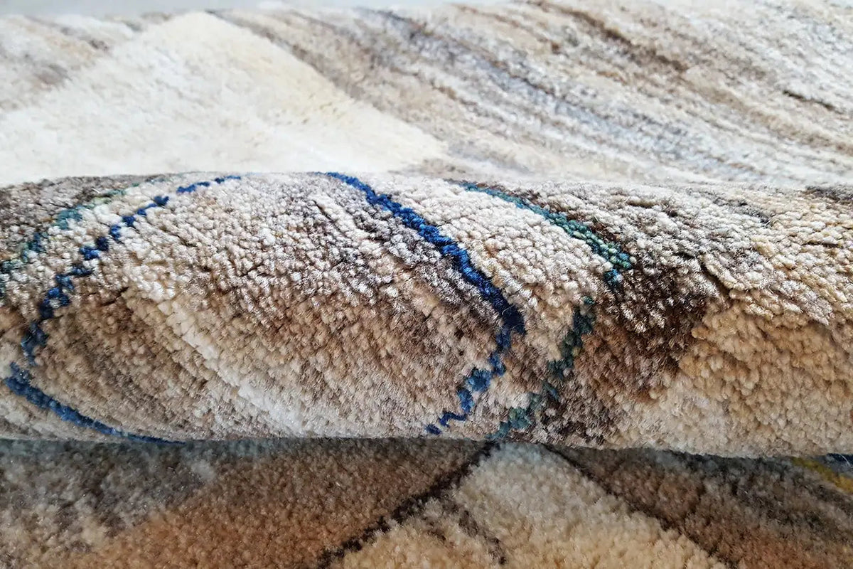 Close-up of a Gabbeh rug: pile with a blue decorative band on a beige background