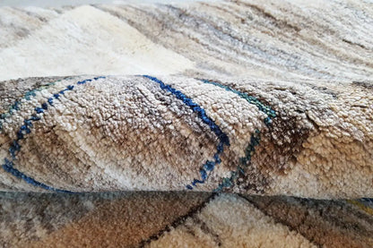 Close-up of a Gabbeh rug: pile with a blue decorative band on a beige background