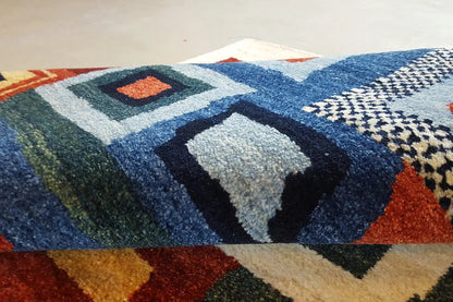 Gabbeh rug with a geometric pattern in blue, red, and beige
