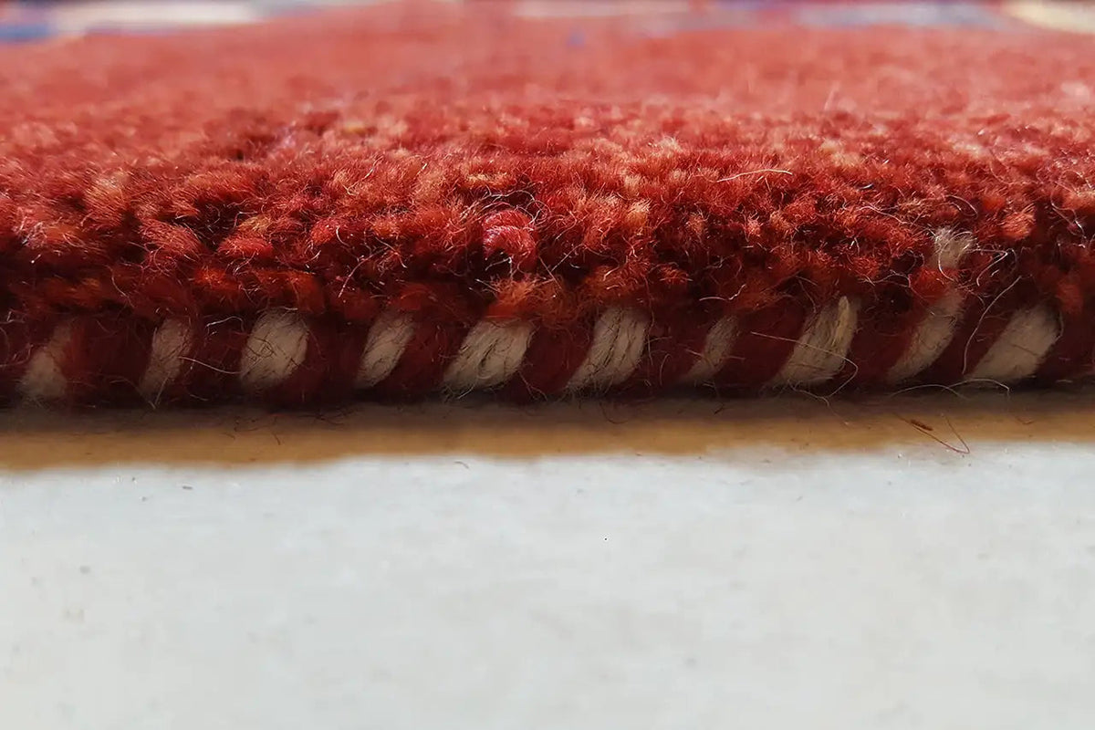 Gabbeh rug: red pile with a bound edge in detail