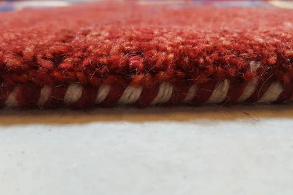 Gabbeh rug: red pile with a bound edge in detail