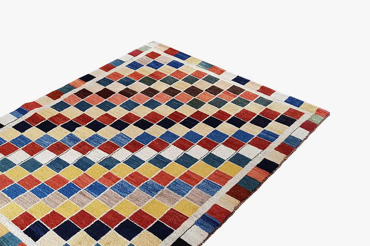 Gabbeh rug (196x132 cm) with a geometric diamond pattern in blue, red, beige, and black