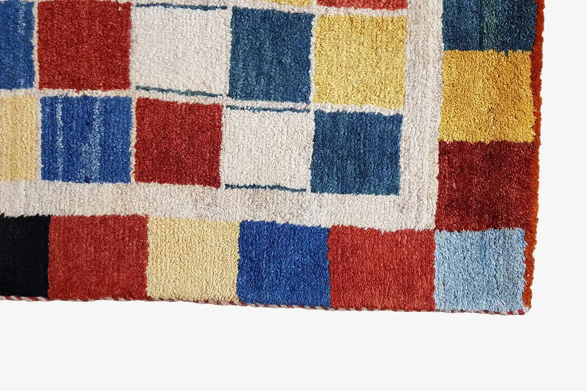 Gabbeh rug (196x132 cm) Detail: square woven pattern in red, blue, yellow, and cream