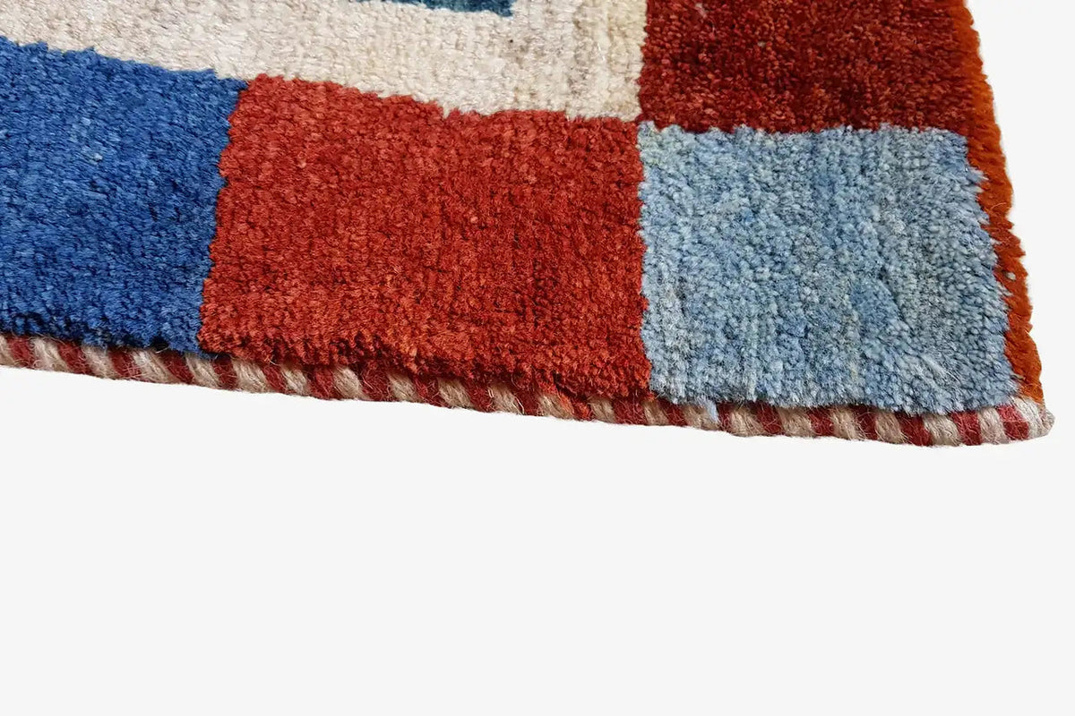 Gabbeh rug (196x132 cm), edge view with a high-pile weave structure in blue and red