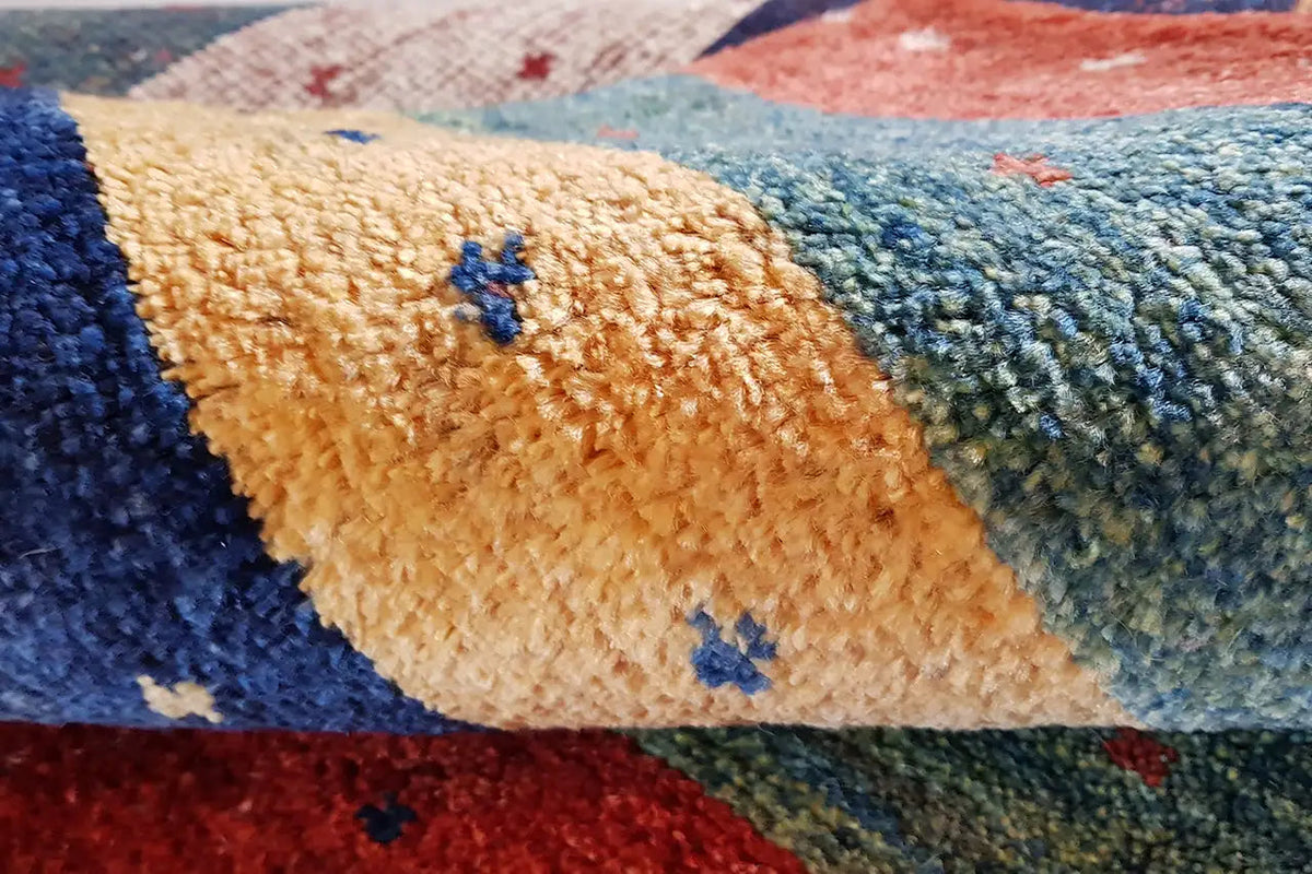 Gabbeh rug with a short pile and small blue accents on beige and blue stripes.
