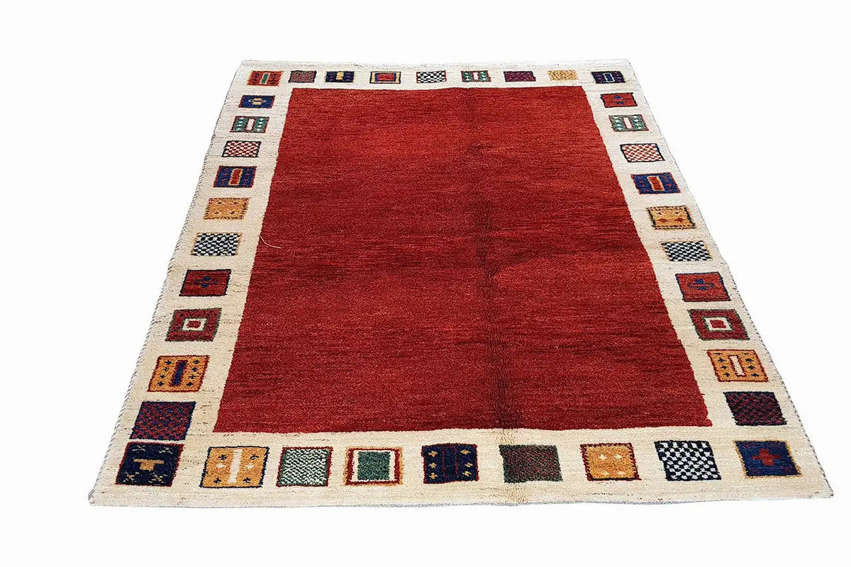 Gabbeh rug (193x145 cm) with a red central area and a geometric multicolored border