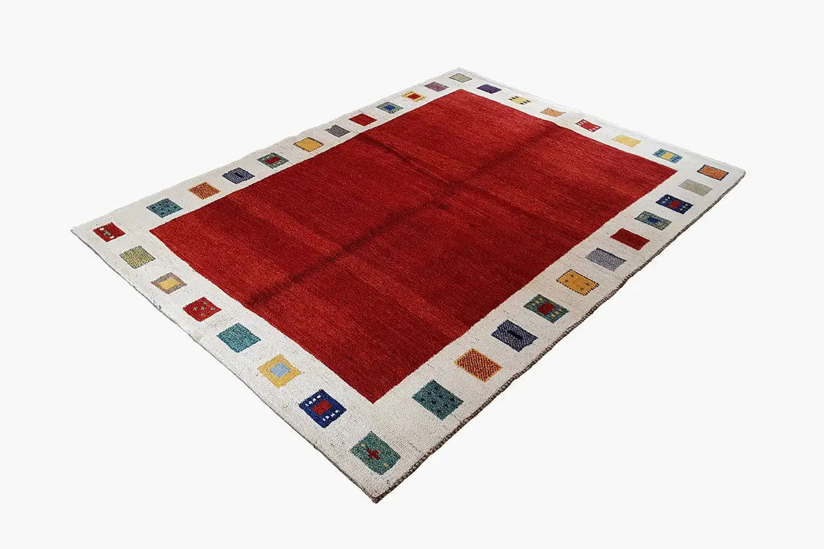 Red Gabbeh rug with a cream-colored border and colorful geometric squares