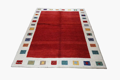 Gabbeh rug: red center with a narrow border of colorful square patterns