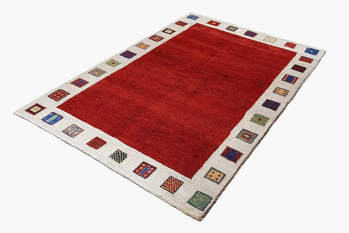 Gabbeh rug, red with a beige border and colorful small ornamental squares along the edges
