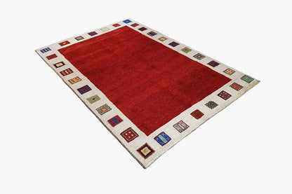 Gabbeh rug with a red central area and beige border featuring multicolored squares