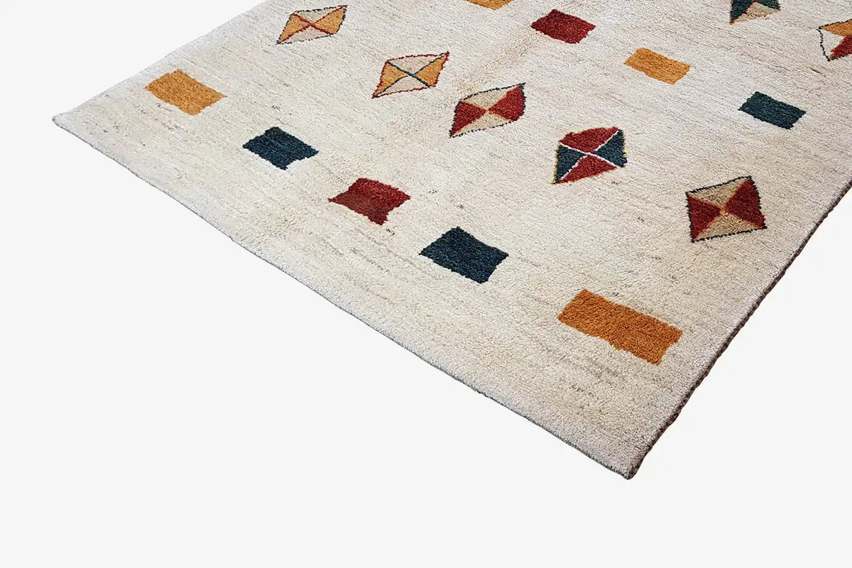 Gabbeh rug with block and diamond motifs in red, dark blue, and ochre on a light background