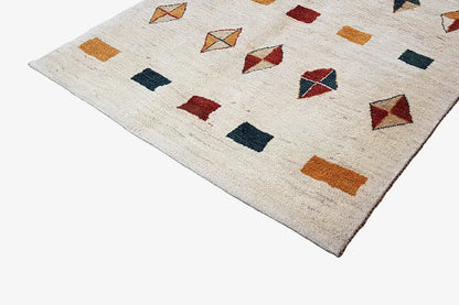 Gabbeh rug with block and diamond motifs in red, dark blue, and ochre on a light background