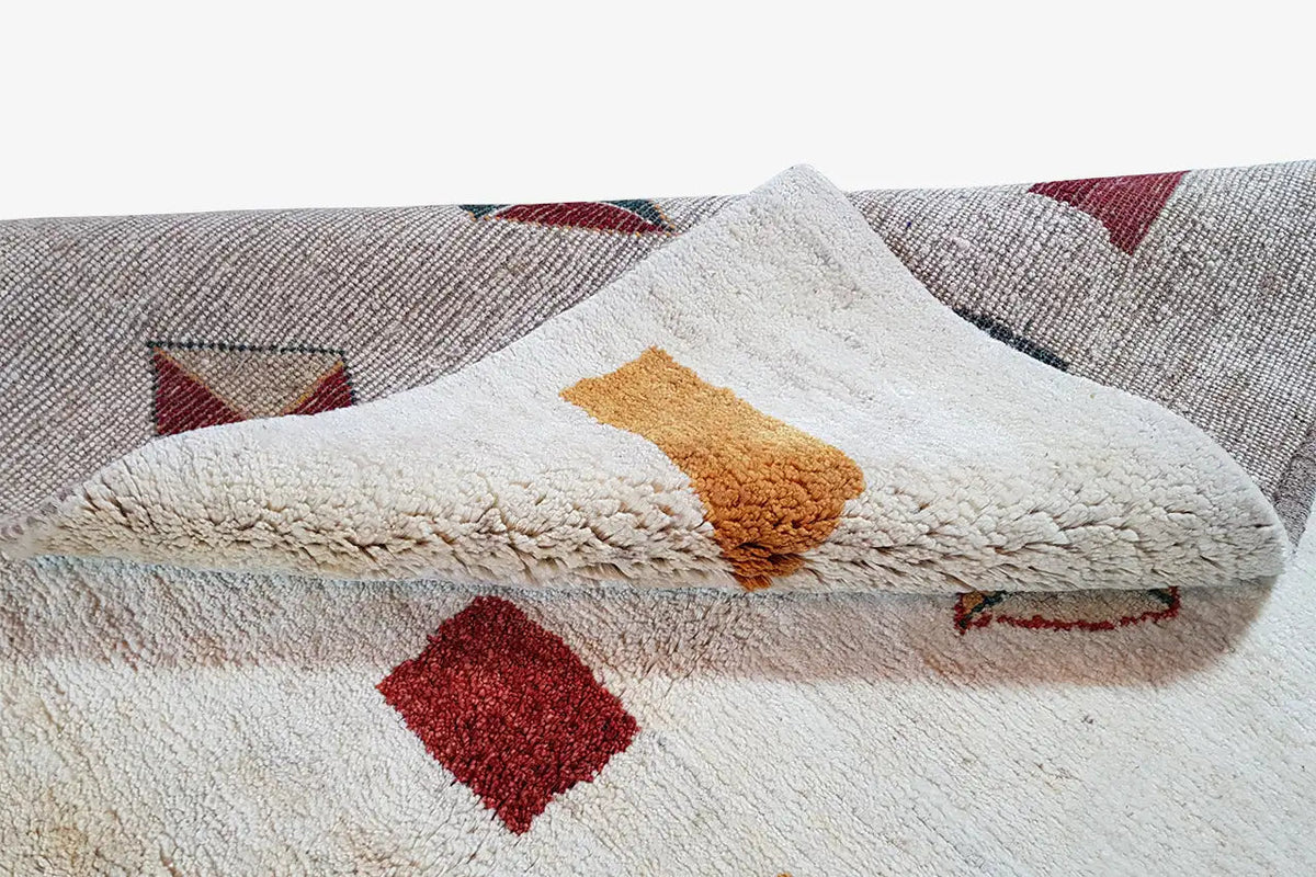 Gabbeh rug detail with a soft pile texture and colorful patterns, edge visible