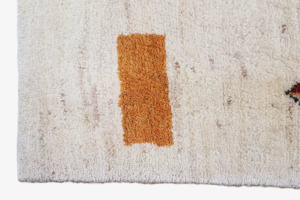 Gabbeh rug close-up: beige pile with an orange rectangle in the center
