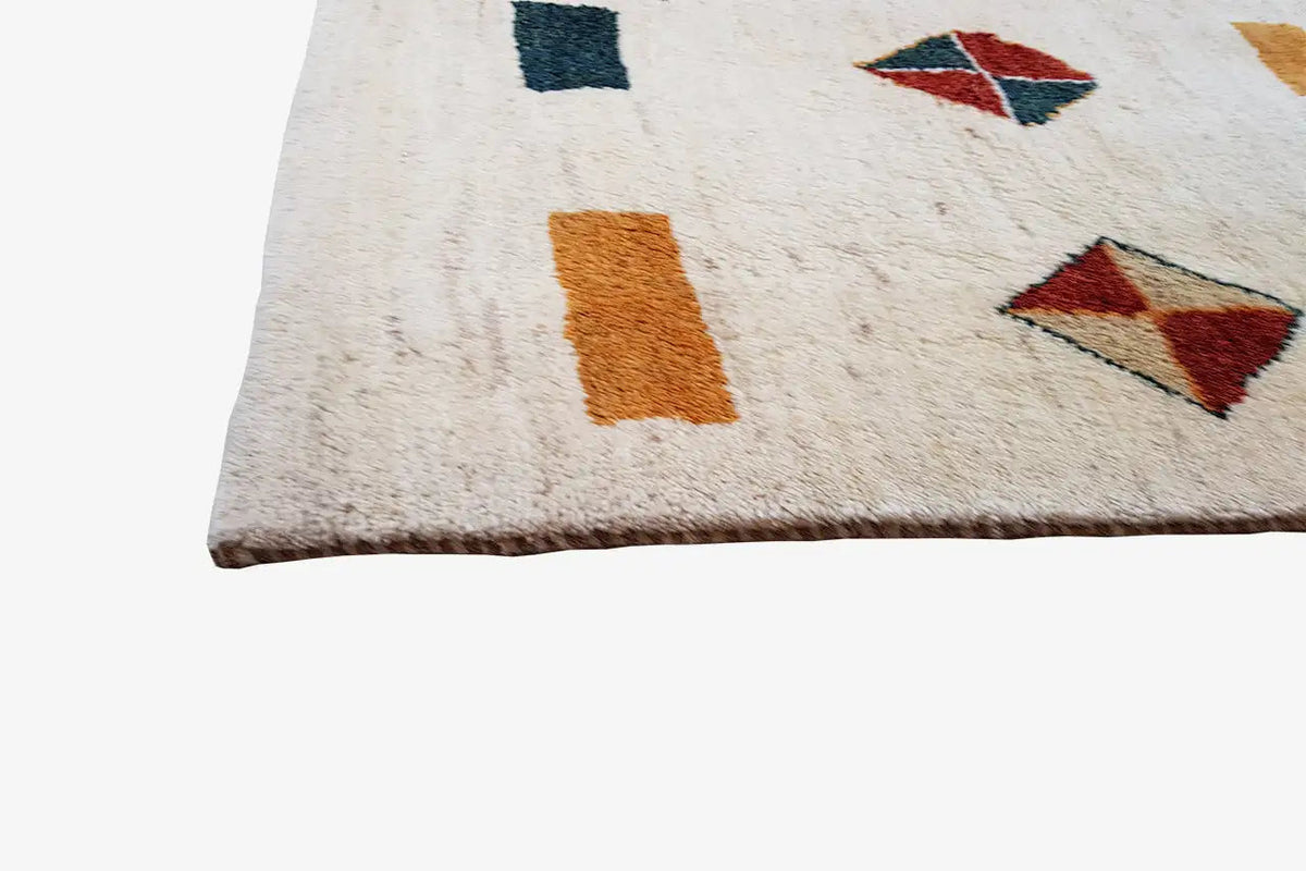 Gabbeh rug corner with small squares and diamonds in red, dark blue, and ochre