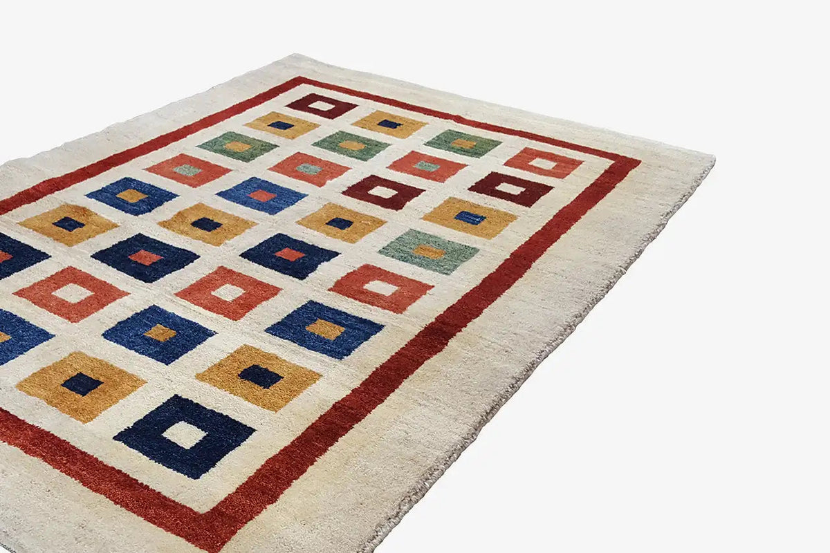 Gabbeh rug (203x129 cm) with a light background, red border, and multicolored squares