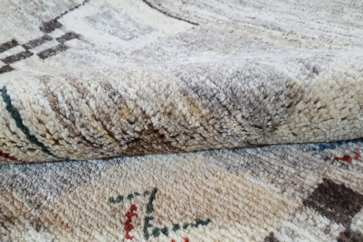 Gabbeh rug: pile and edge in detail, beige background with patterned threads