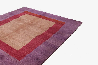 Gabbeh rug spread-out corner: purple border, red ground, beige inner field.