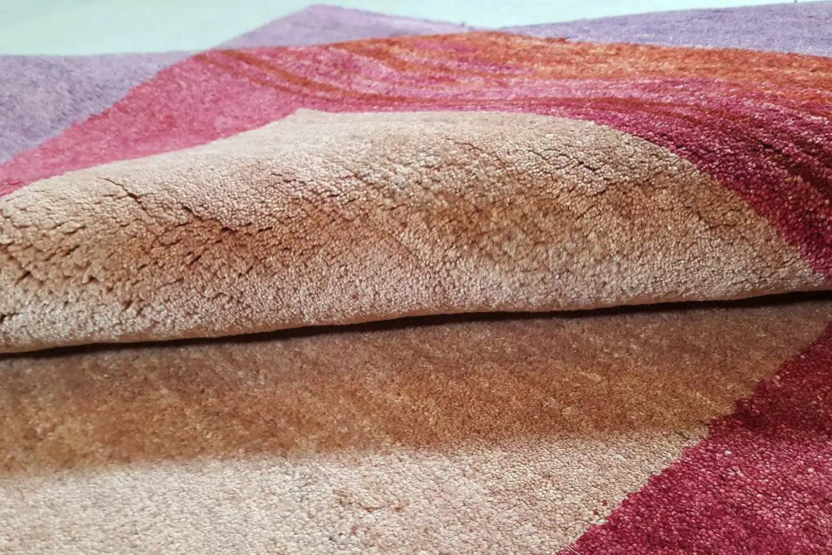 Gabbeh rug pile height detail: beige central field with a red border and purple background.