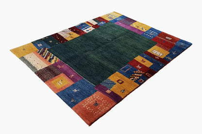 Gabbeh rug with a dark green center and colorful patchwork border