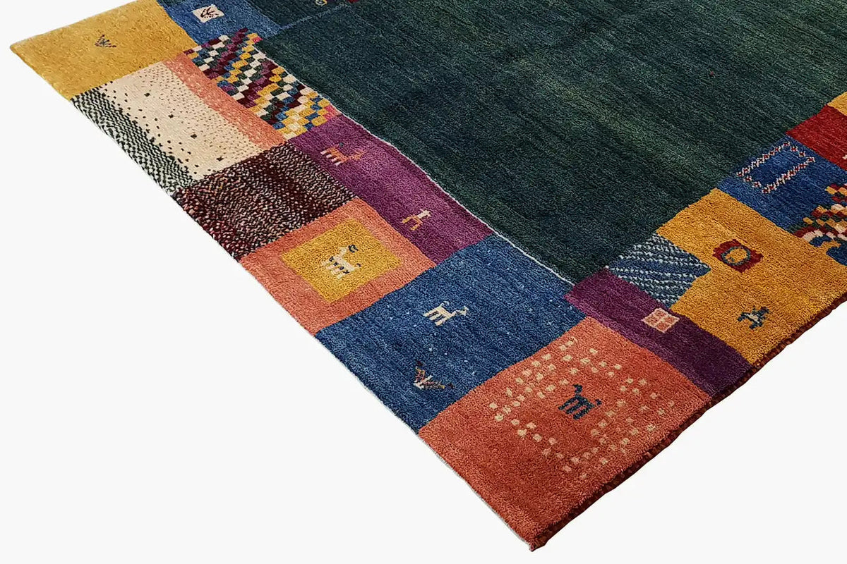 Gabbeh rug, dark green center, multicolored patchwork areas around the edges