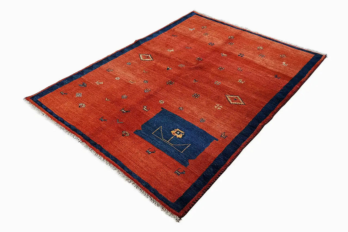 Red rectangular rug with a blue border, small multicolored patterns, and fringes