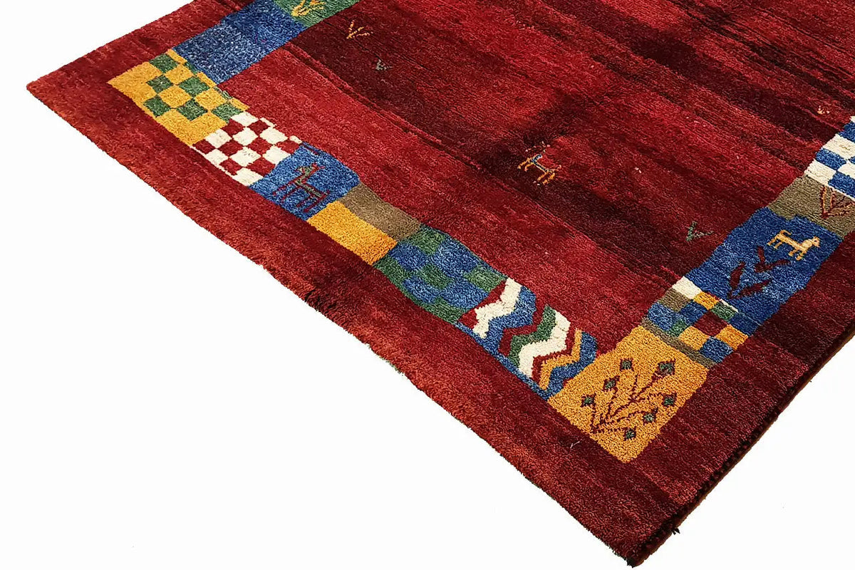 Gabbeh rug: red grid with multicolored block and elephant motifs along the edge