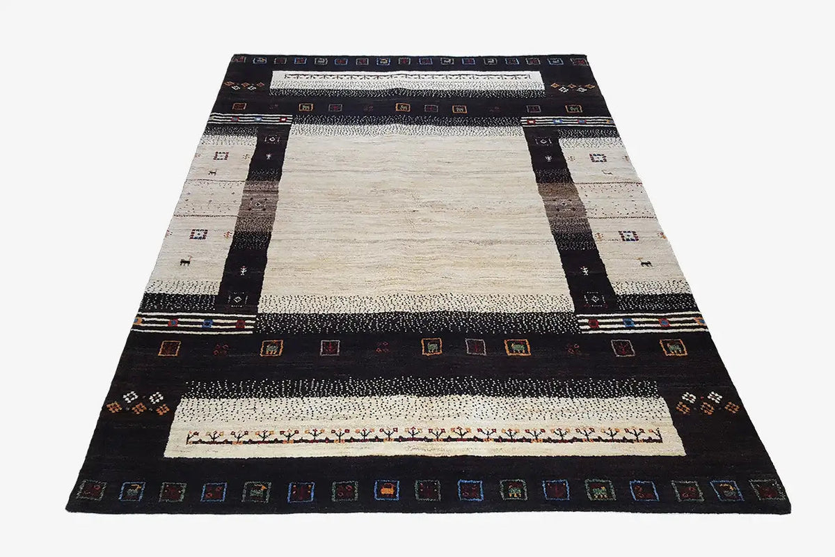Gabbeh rug in triangular view: black outer frame, beige surface with decorative border
