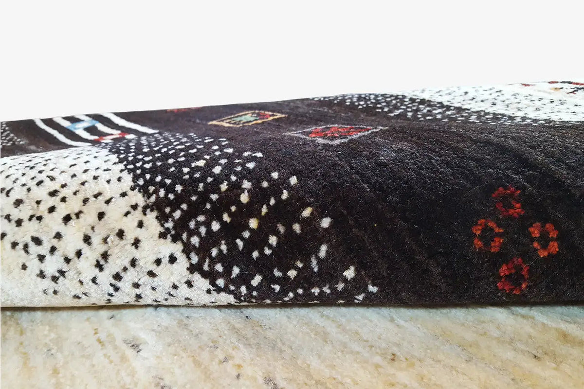 Close-up of the pattern: black pile with beige areas and individual colored accents
