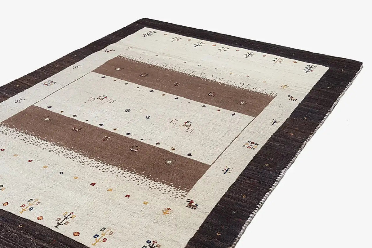 Gabbeh rug 175×117 cm, close-up: dark border, cream with brown fields