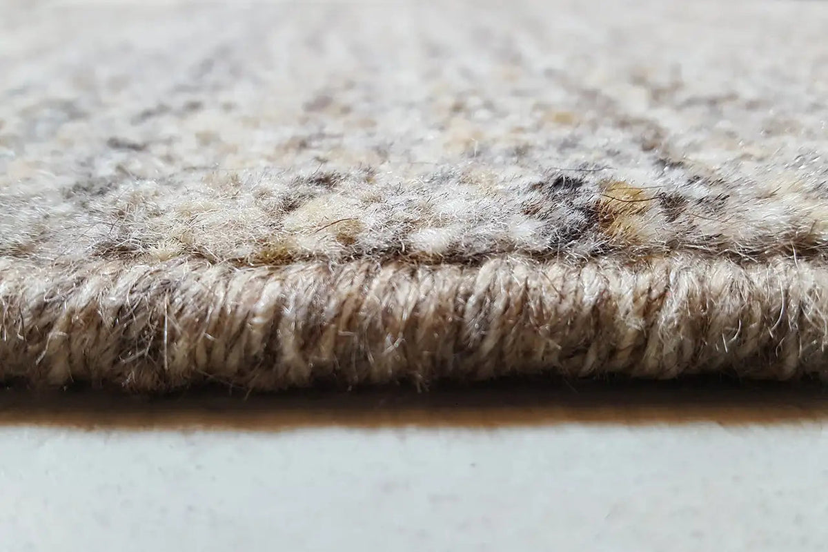 Close-up of a Gabbeh rug edge with a dense pile in light gray and beige tones