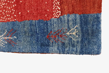 Gabbeh rug border: red-and-blue section with embroidered star/arrow ornaments