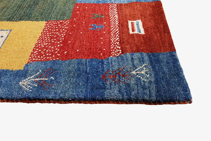 Lower edge of a Gabbeh rug with patchwork: red, blue and yellow sections with ornaments