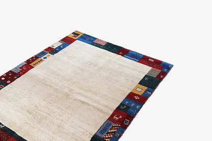 Gabbeh rug 210x149 cm with a beige center and multicolored patchwork border