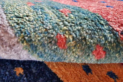 Gabbeh carpet close-up: irregular dots and pile in shades of blue, green, and red