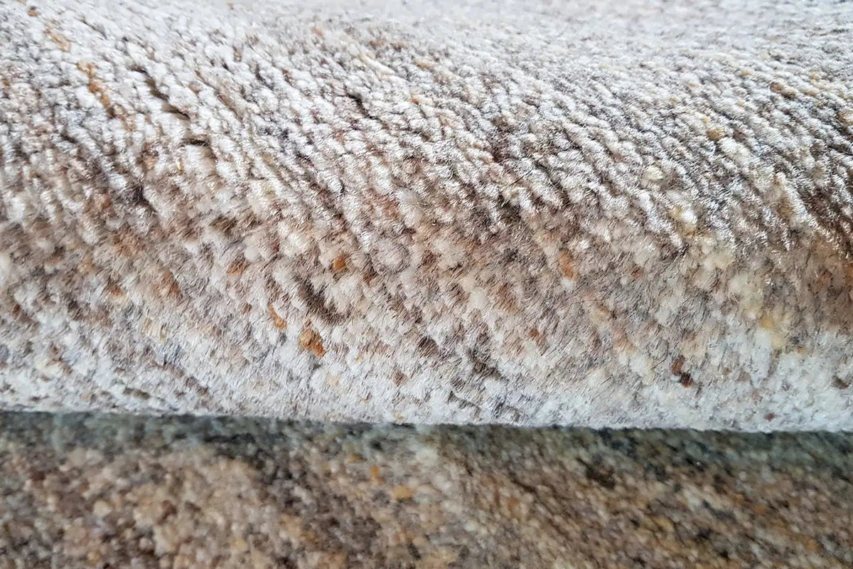 Gabbeh natural rug: multicolored pile texture, beige-brown, close-up view of the rug edge